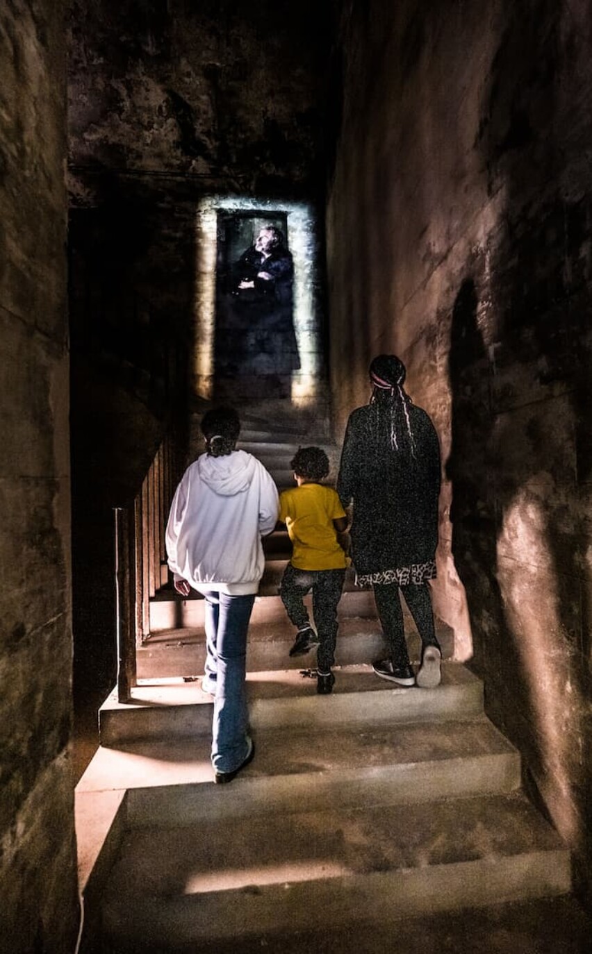 History Whisperer interactive XR museum experience family climb steps, warder coming out of wall